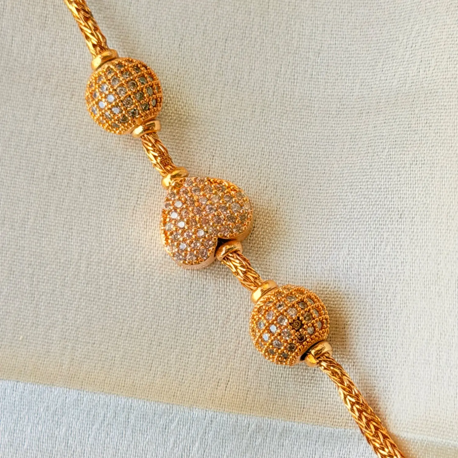 Elegant 26 Inches Gold-Plated Chain Necklace with Stone-Studded Spheres and Central Heart Charm