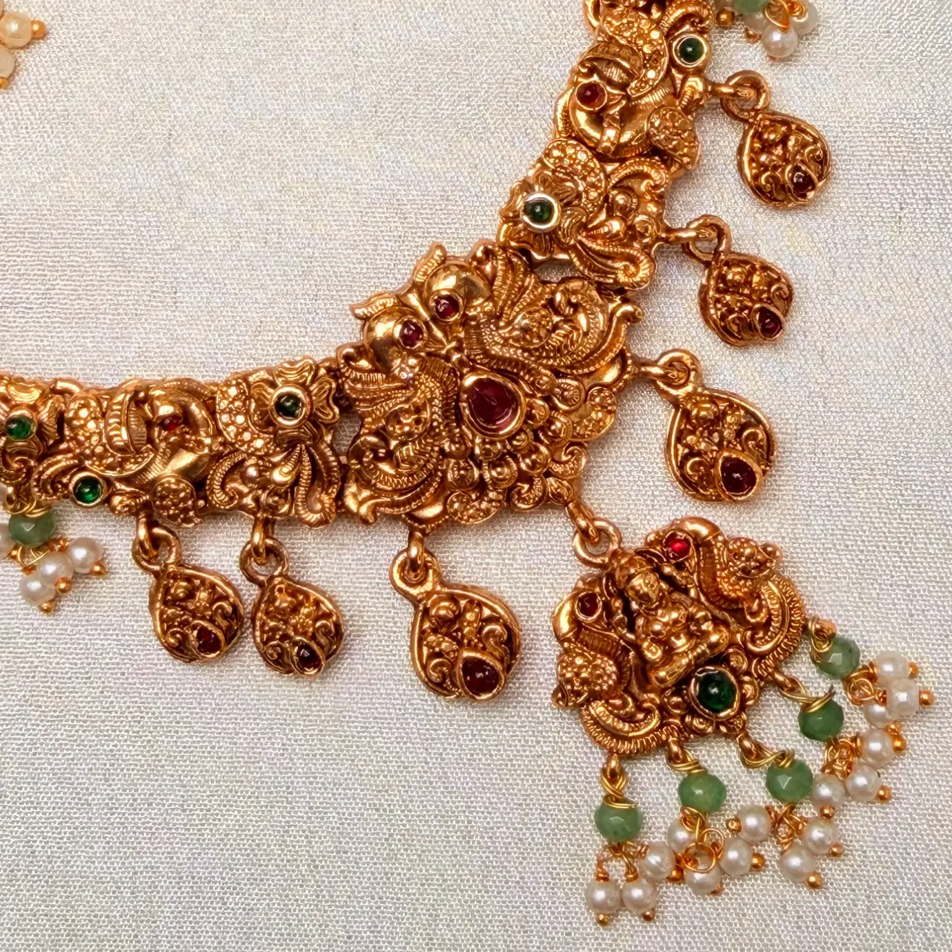 Antique Matte Gold Goddess Lakshmi & Mayuri Nakshi Neckpiece with Hanging Kemp Leaf Charms, Green Beads & Matching Pearl Jhumkas SJSN075