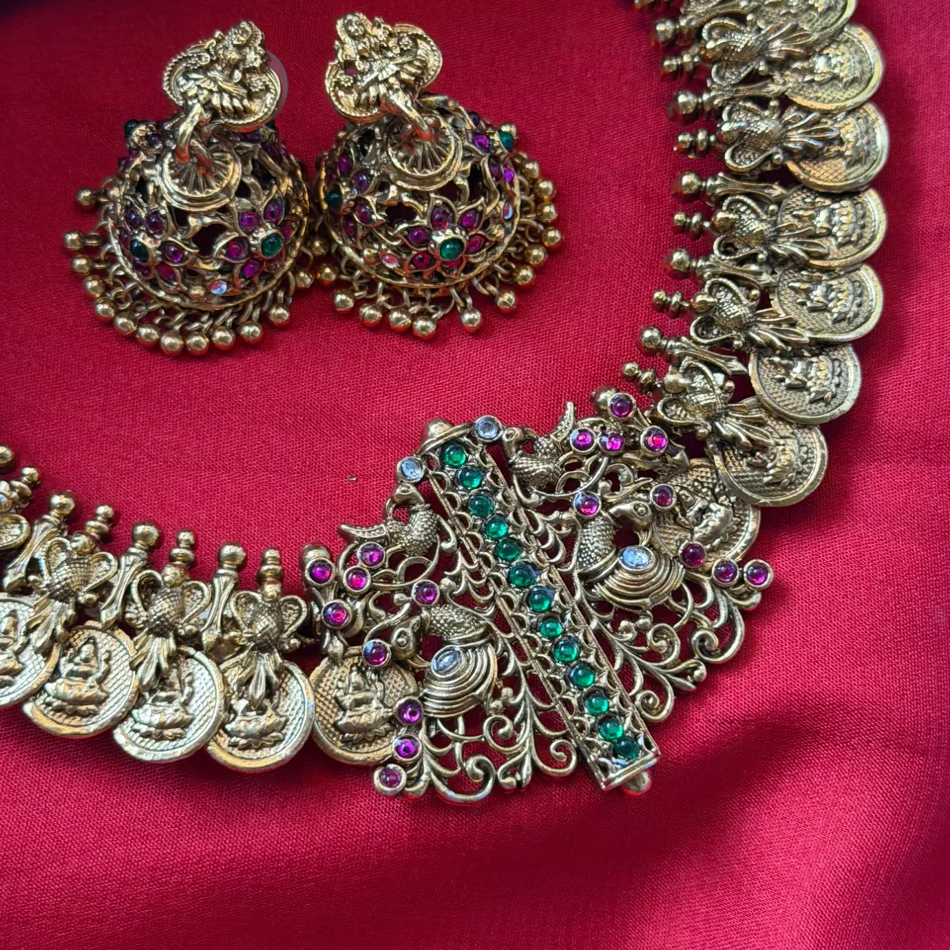 Gold Replica Antique Matte Charvi Kasu Mala (Lakshmi Coin Necklace) with Asymmetrical Filigree Peacock Side Brooch, Emerald-Ruby Kemp Bar & Kemp Jhumkas