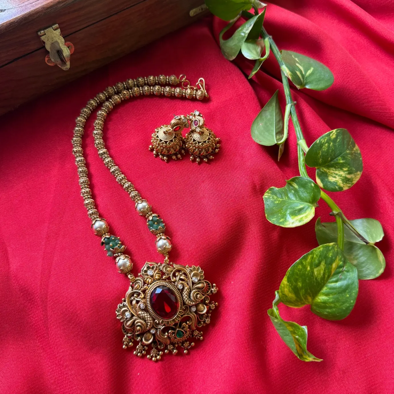 Gold Replica Antique Ruby Oval Solitaire Filigree Pendant Necklace Set – Beaded Mala Chain with Emerald & Pearl Accents, and Matching Temple Jhumkas